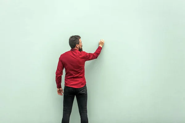 Jonge volwassen zakenman op grijze muur schilderen — Stockfoto