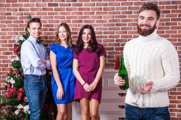 Arkadaşlar konsepti ile Noel zamanı. Sakallı adam şampanya ve iki cam holding.