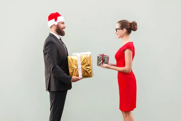 Geluk koppel op zoek elkaar en houden de doos van de gift. — Stockfoto