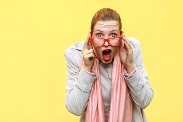 Shocked woman wearing coat, pink scarf, opening mouths , having — Zdjęcie stockowe