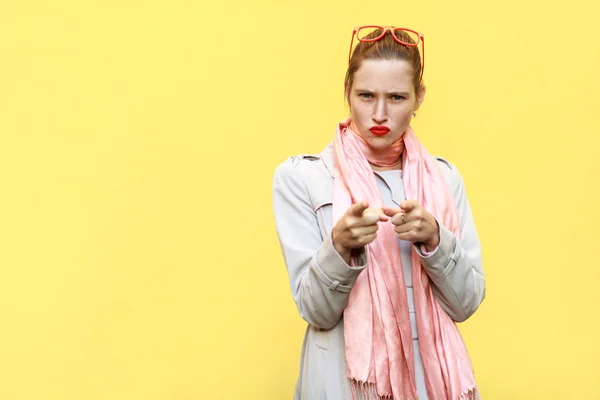 La mujer seria, vistiendo abrigo, teniendo miradas de ira, señalando — Foto de Stock