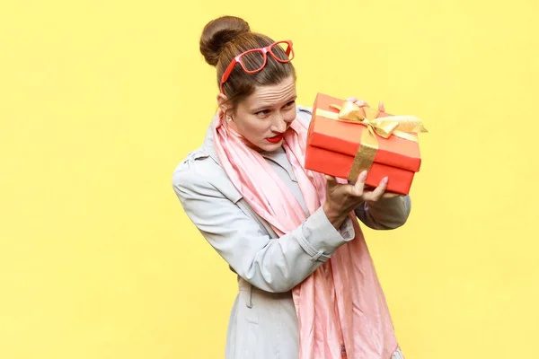 Qu'y a-t-il ? Femme rusée regardant boîte cadeau et veulent trop o — Photo