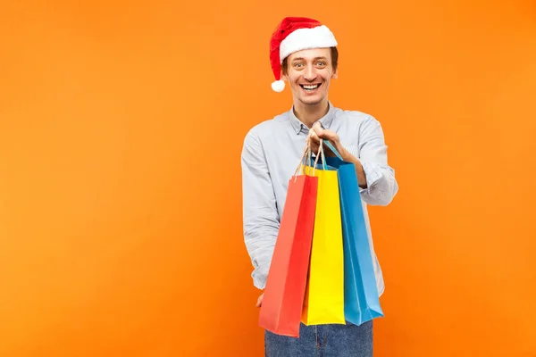 Jovem adulto alegre homem no Natal chapéu vermelho, dente sorridente, sho — Fotografia de Stock