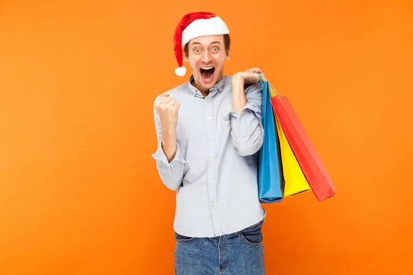 Felicidade homem de sucesso segurando pacotes, mostrando sinal de vitória e — Fotografia de Stock