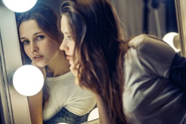 Çiller kadın aynaya bakıyor. Seksi esmer güzel duruyor