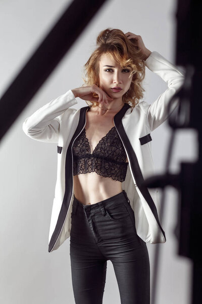 Playfully young adult blonde, posing and looking at camera.