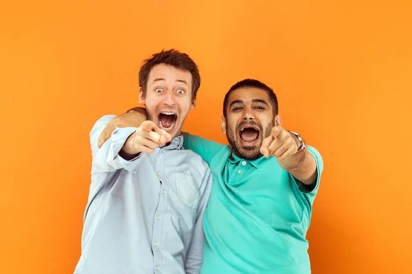 Primer plano. Dos amigos de la felicidad abrazándose, señalando el surf —  Fotos de Stock