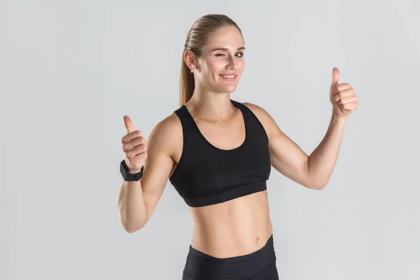 Athletic woman showing thumbs up — Stock Photo, Image