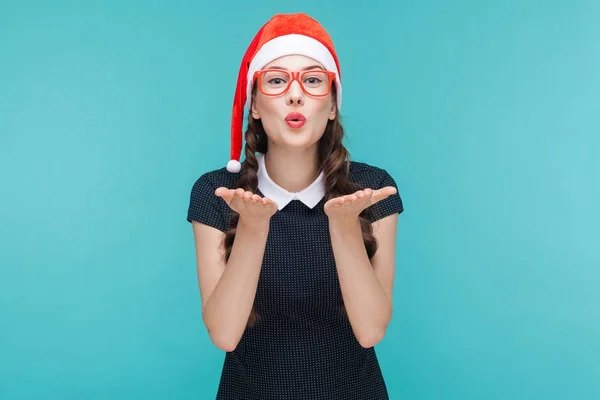 Frau mit Weihnachtsmannhut bläst Kuss — Stockfoto