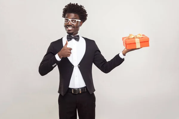 Africano homem polegares para cima e segurando caixa de presente . — Fotografia de Stock