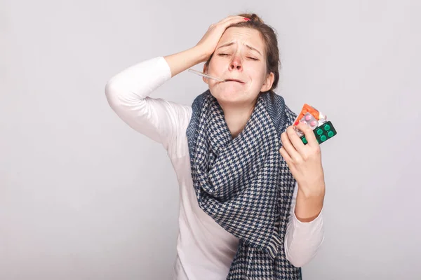 Young adult sick woman have temperature, holding many pills. — Stock Photo, Image