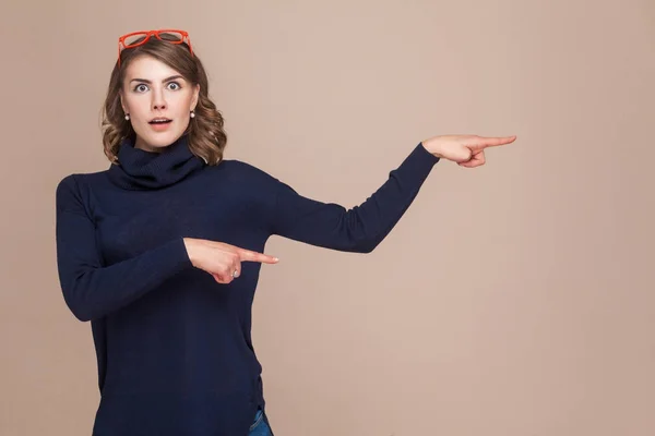 Mujer emocional mirando a la cámara y señalando con los dedos a la copia — Foto de Stock