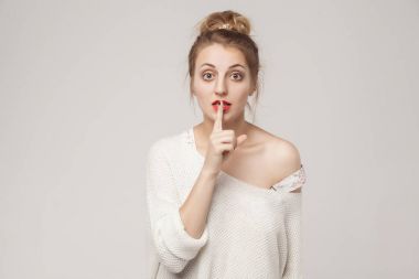Gizlilik işareti. Blone kadın iri gözlü gösteren gizli oturum şşş. Stüdyo çekim, izole gri arka plan üzerinde