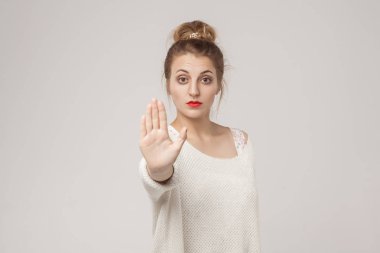 Yetişkin kadın gösterilen durdurmak veya ban Blone genç oturum. Atış, arka planı gri studio