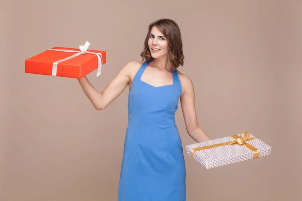 Holiday or birthday concept. Happiness woman holding two gifts boxes. Studio shot