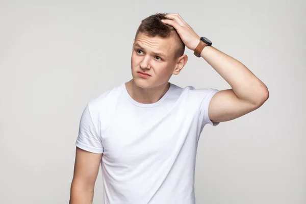 Hmm let my think. Creativity boy looking down and thinking. Studio shot, gray background