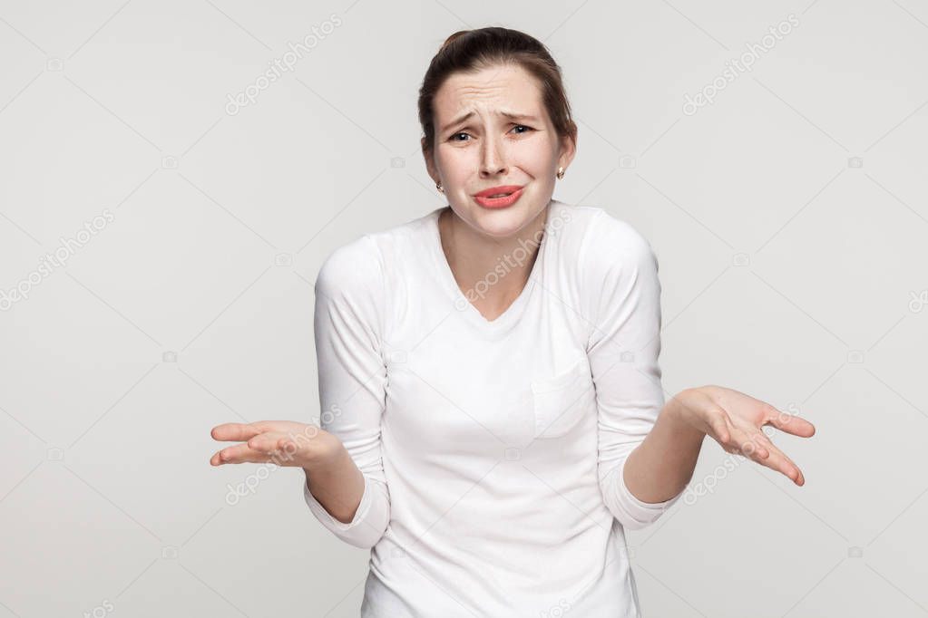 Emotional girl cry and looking at camera. Studio shot, gray background