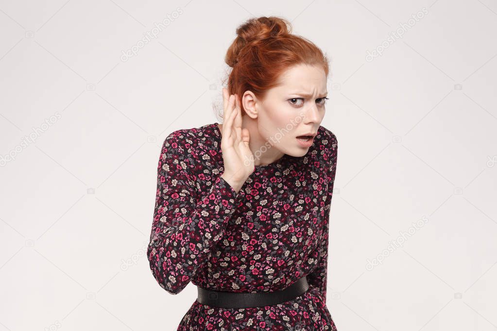 redhead lady holding palm near ear, concept I can not hear you