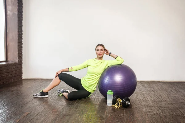 Mulher Desportiva Apoiou Bola Fitness Violeta Relaxante Enquanto Sentado Chão — Fotografia de Stock