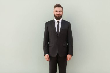 siyah elbiseli gri arka plan üzerinde poz başarılı gülümseyen neşeli iş adamı