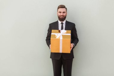 hediye kutusu gri arka plan üzerinde dişlek gülümseme ile veren başarılı bankacı
