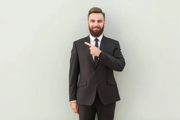 Joven Hombre Negocios Barbudo Guapo Con Sonrisa Radiante Apuntando Con — Foto de Stock