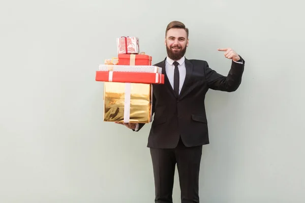 Schöner Geschäftsmann Zeigt Mit Dem Finger Auf Geschenkboxen Und Schaut — Stockfoto