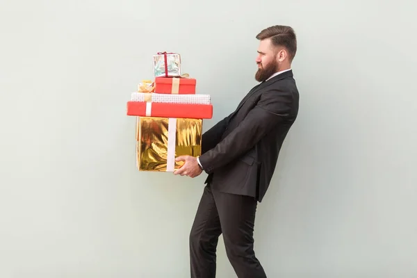 灰色の背景に重いギフト用の箱の山を押し疲れの上司 — ストック写真