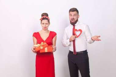 hediye kutusu tutarak ve şaşkın adam gri arka plan, Sevgililer günü hayal kırıklığı kavramı üzerine karışık yakınındaki ağlayan kadın 