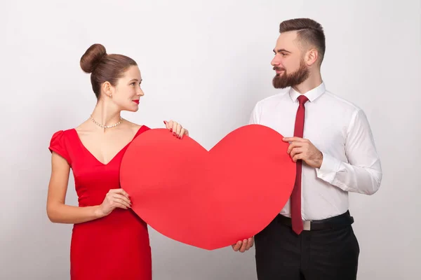 Schönes Paar Hält Rotes Herz Und Schaut Einander Auf Grauem — Stockfoto
