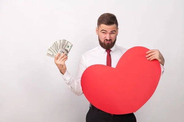 実業家の手お金と灰色の背景は バレンタインの日の概念に大きな赤いハートの保持 — ストック写真