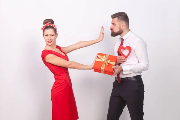 無視して贈り物と灰色の背景は バレンタインの日の概念の手で心を持ったビジネスマンを拒否して赤いドレスを着た女性 — ストック写真