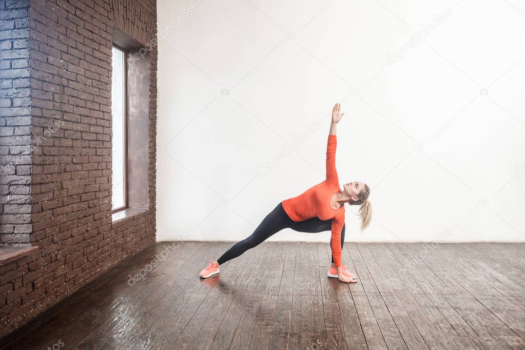  woman instructor doing pilates pose at loft interior room  