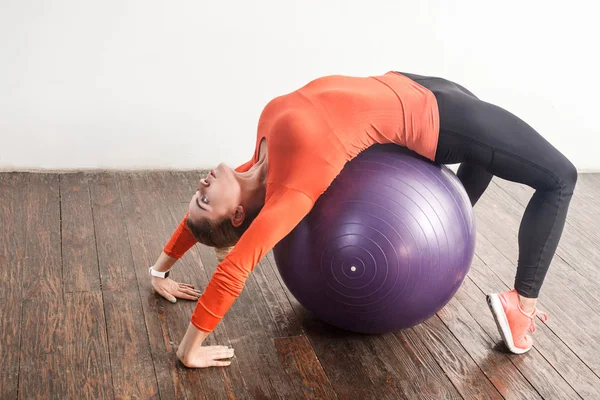 energy woman balancing and doing bridge pose on fitness ball