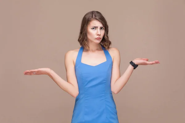 Σύγχυση Γυναίκα Μπλε Φόρεμα Υψώνοντας Χέρια Ανοιχτό Καφέ Φόντο Επιλογή — Φωτογραφία Αρχείου