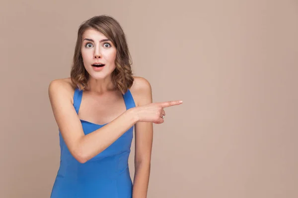 Förvånad Affärskvinna Med Chockad Ansikte Blå Klänning Pekar Finger Sidan — Stockfoto