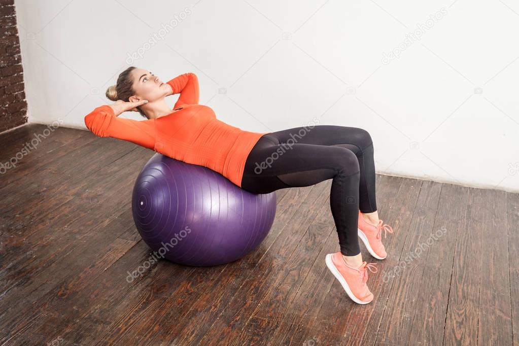 energy woman balancing and doing workout on fitness ball