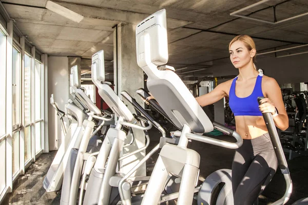 Blond Sportig Kvinna Utbildning Elliptiska Tränare Gymmet — Stockfoto