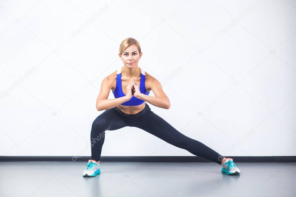 happy fitness woman doing stretch exercising and looking at camera