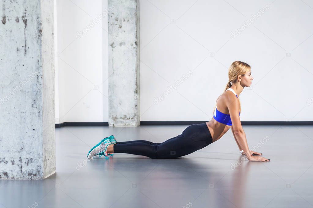 blonde activity woman practicing yoga posture of cobra
