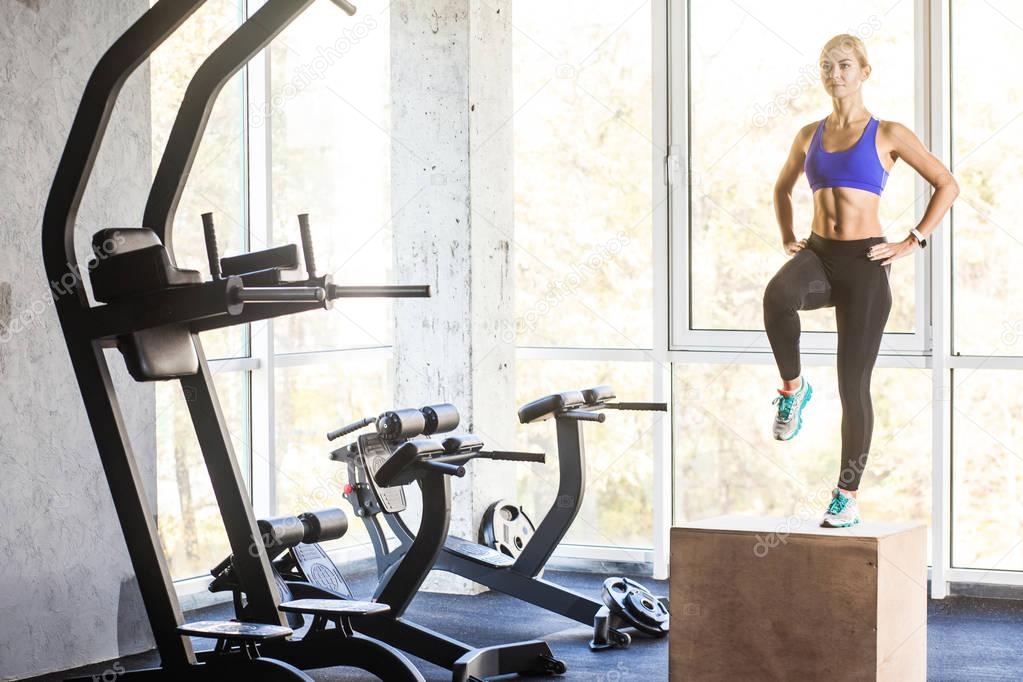 woman stepping up on cube in gym, crossfit concept 