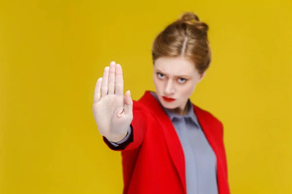 Serieus Roodharige Zakenvrouw Rode Jas Hand Stopbord Tonen Gele Achtergrond — Stockfoto