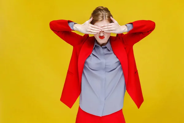 redhead businesswoman in red jacket closed eyes by hands