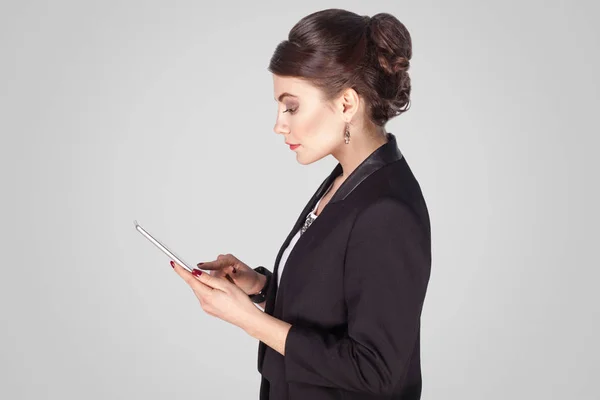 在灰色背景下使用 Tablet 的女实业家侧面 — 图库照片