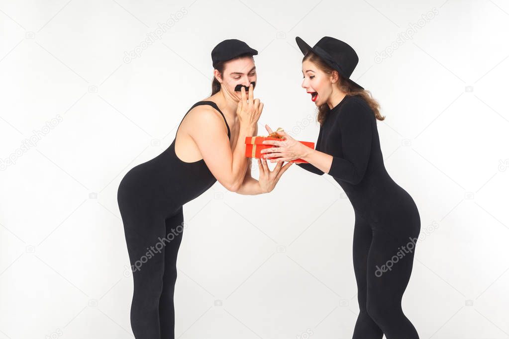 man with fake mustache giving gift box to shocked woman isolated on white background, birthday concept  