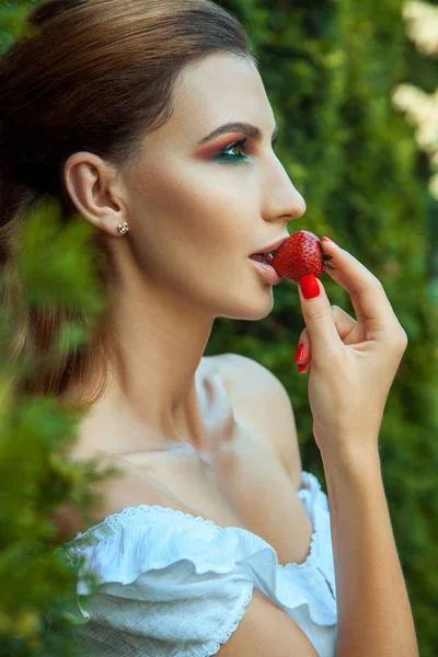 年轻的成年妇女与漂亮的脸和性感的嘴嘴唇吃红甜草莓肖像 — 图库照片