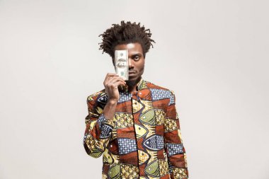 bir dolar tutan ve gri arka plan üzerinde kameraya bakarak kızgın, Afrikalı-Amerikalı adam