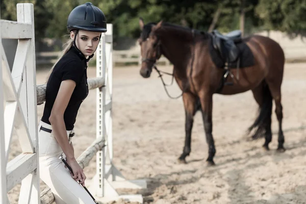 prestige sportsman posing in hippodrome near horse, sport and fashion concept