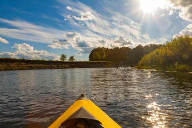 parlak sarı kano kürek çekmeye güneşli yaz günü, yakın çekim orman çevrili Nehri üzerinde yay 