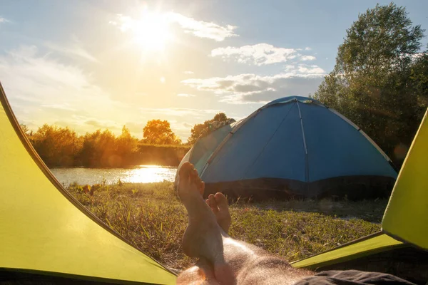 在阳光明媚的夏日 旅游帐篷中的雄腿与森林河岸的景观 — 图库照片